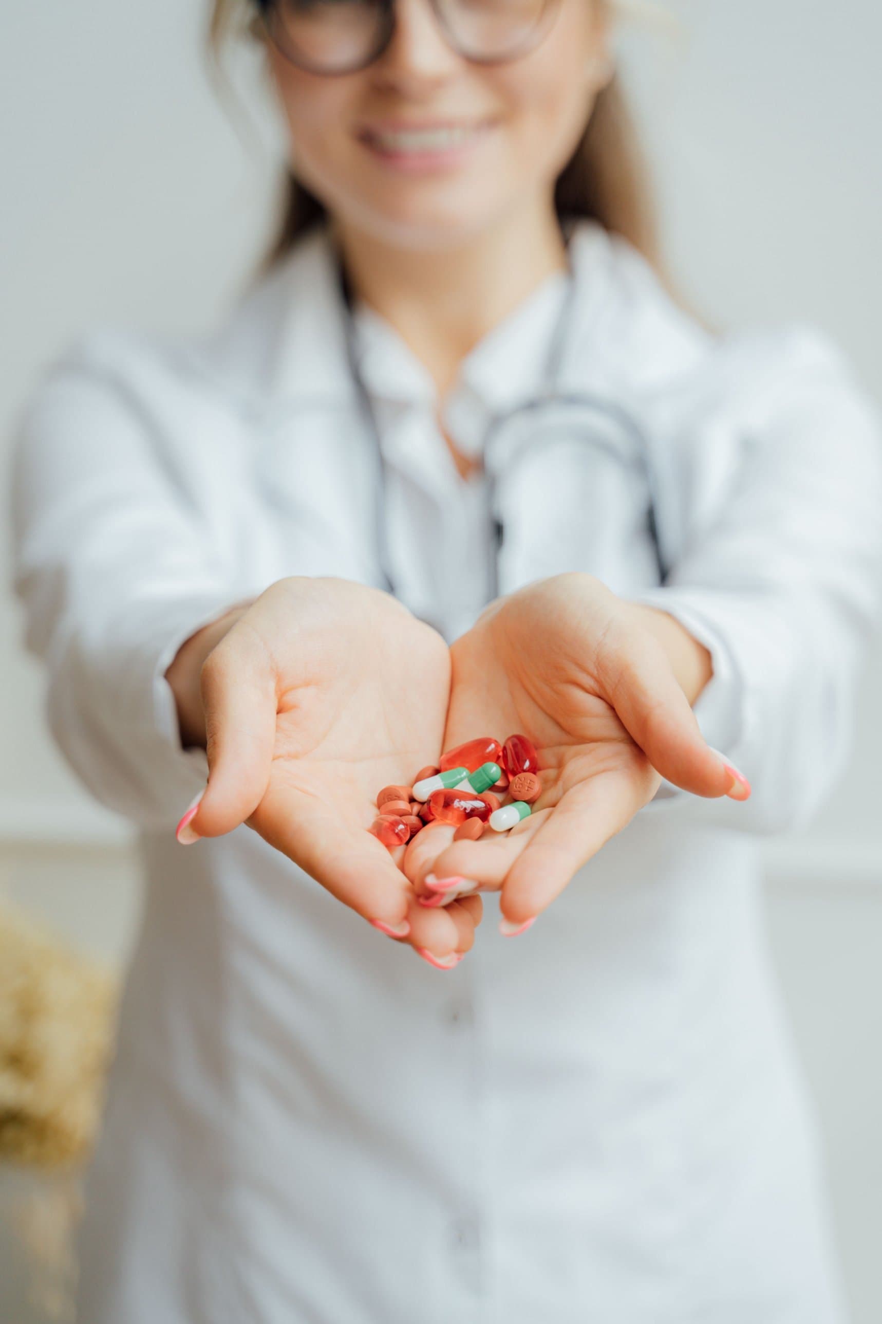 Pharmacist holding a handful of capsules and tablets