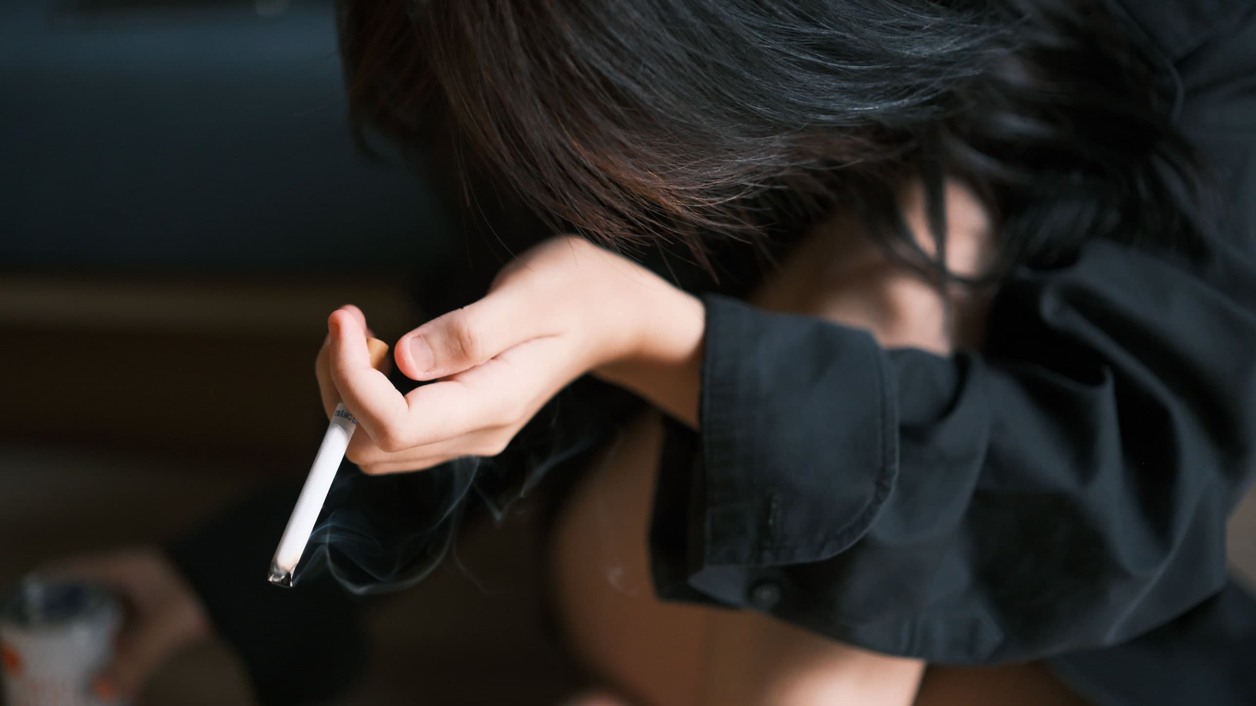 Person holding a lit cigarette